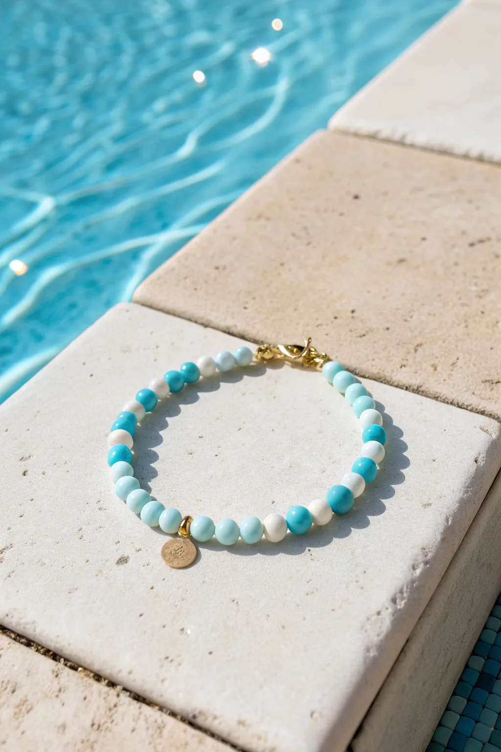 Icy blue and white clay bead bracelet styled poolside for a fresh blue-on-blue summer look