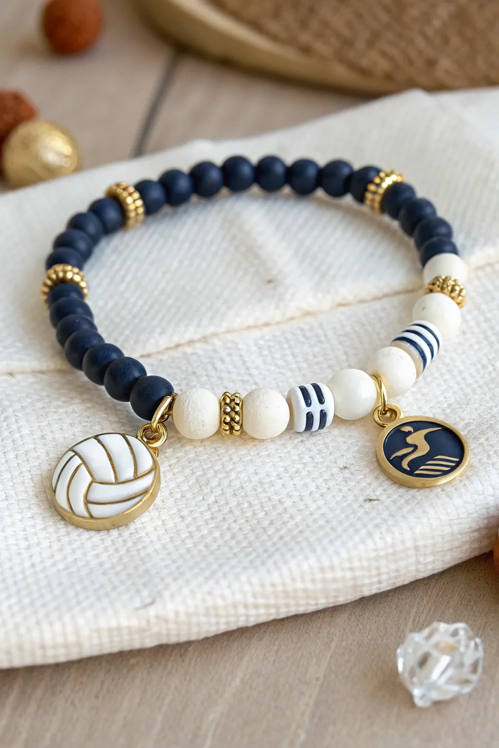 Multi-sport clay heishi bracelet with a volleyball bead and subtle sport charms in school colors.