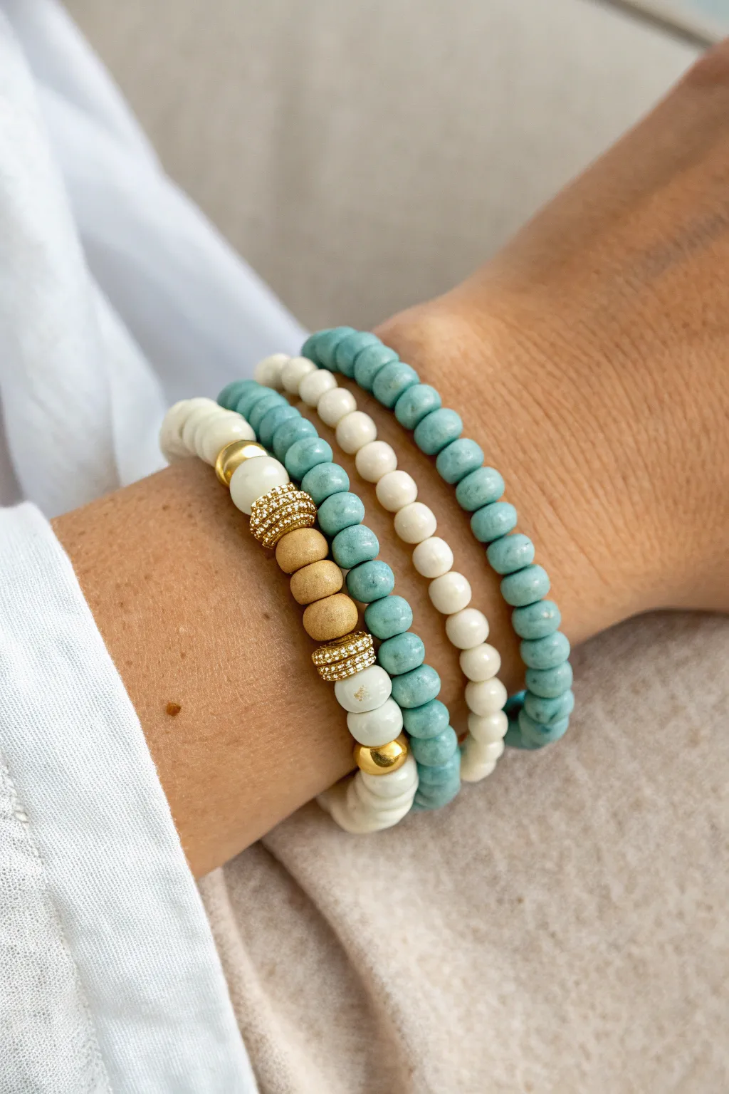 Coastal stack of clay bead bracelets in ocean blues, sand tones, and subtle gold accents.