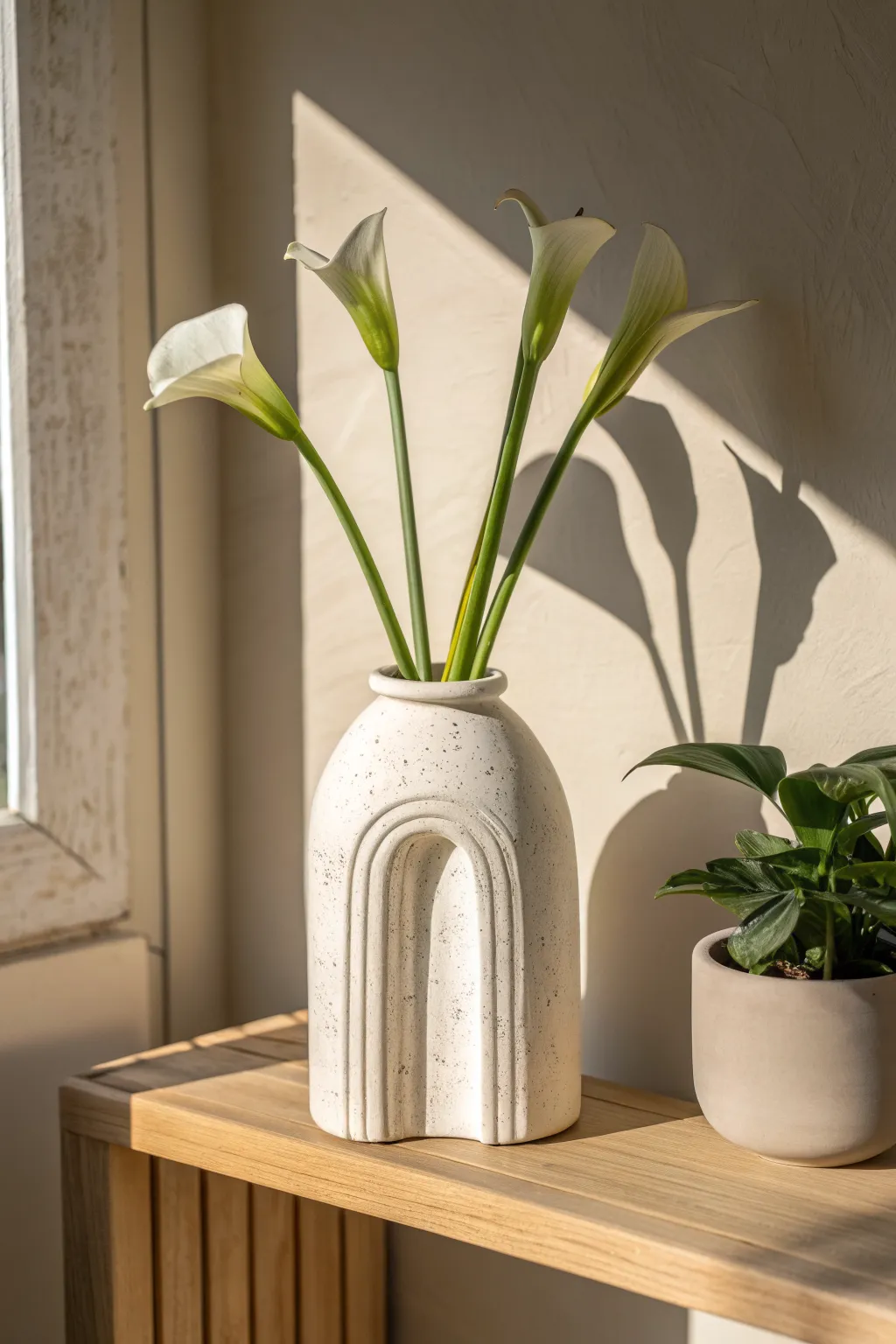 Modern arch-shaped air dry clay vase planter with bold stems, minimal shelf styling