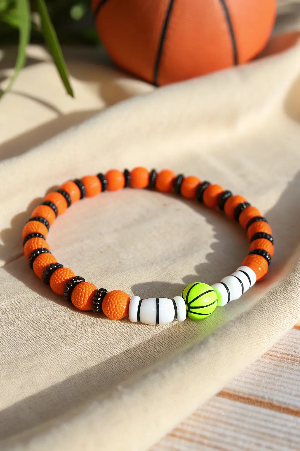 Neon pop clay bead bracelet in orange, black, and white with a bright team-accent band.