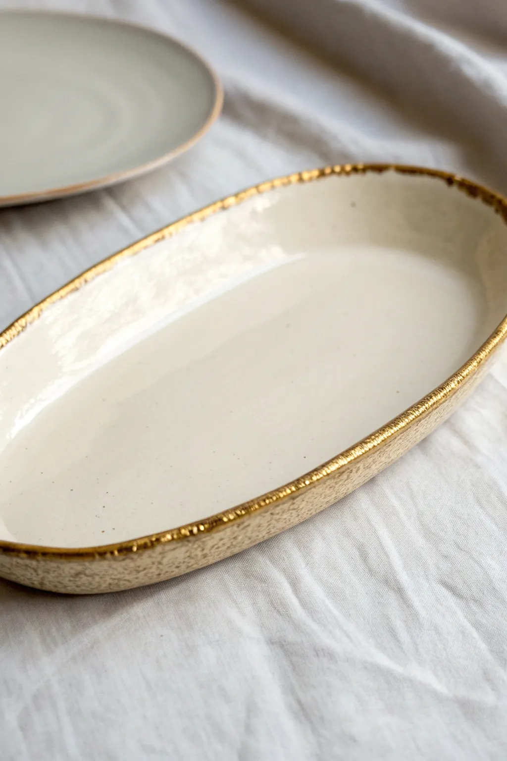 Minimal ceramic tray with a delicate metallic rim, glowing softly in warm natural light