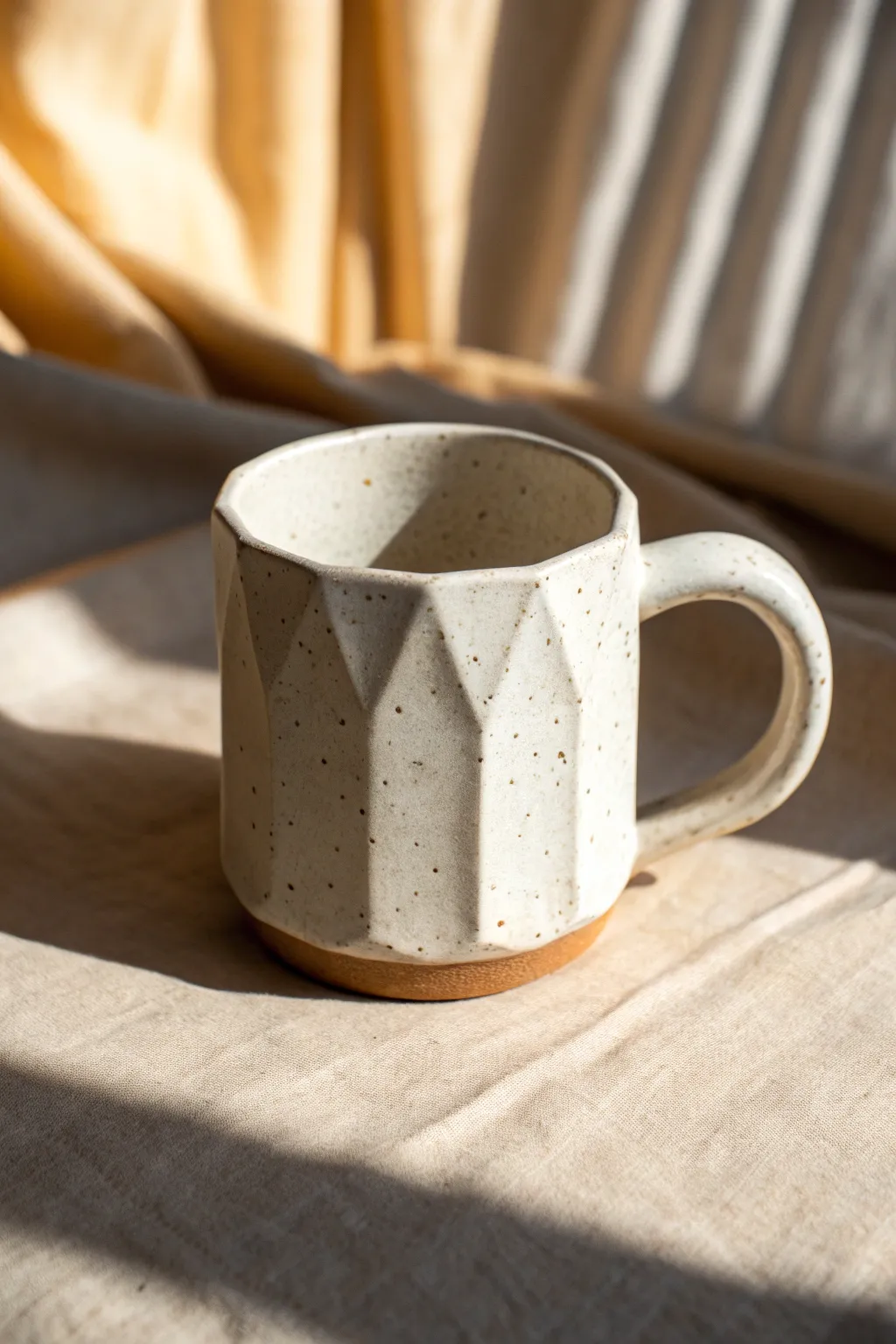 Easy faceted clay mug: soft planes, minimal glaze, and side light for gentle shadows.