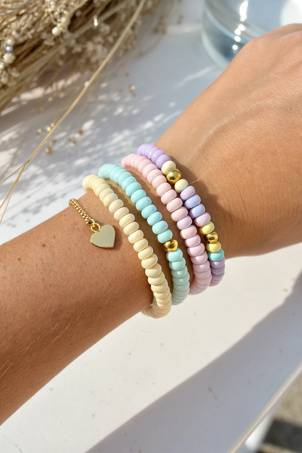 Pastel preppy clay heishi bracelet stack with gold spacers and a tiny heart accent, bright and clean.