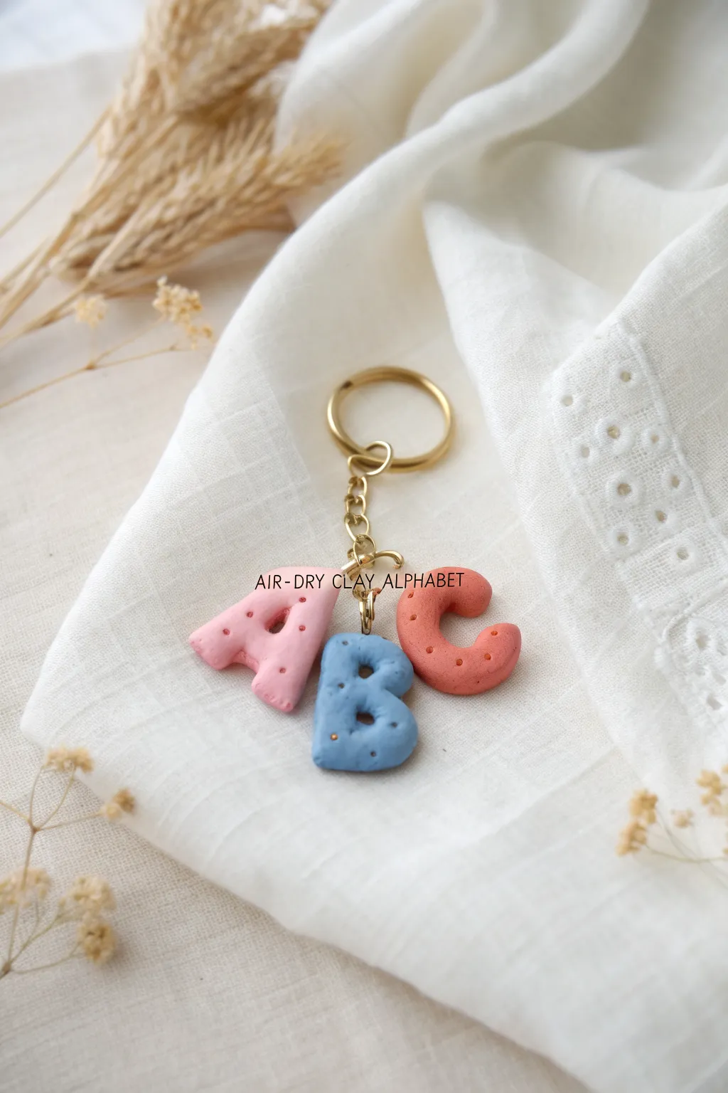 Puffy clay letter keychain charm in bold pastel tones, dotted details, and sweet minimalist faces.