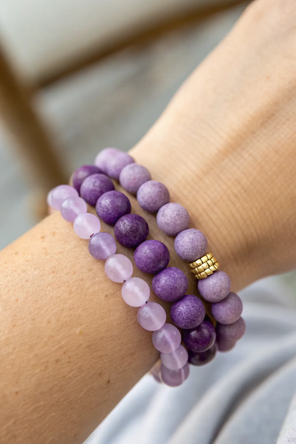 Three stacked purple clay bead bracelets in lilac, violet, and plum for an amethyst look