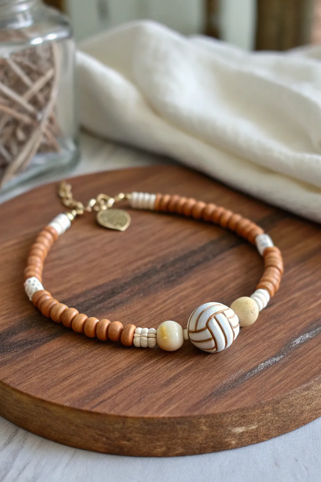 Hidden lucky volleyball charm on a minimalist clay heishi bracelet in soft neutral game-day tones.