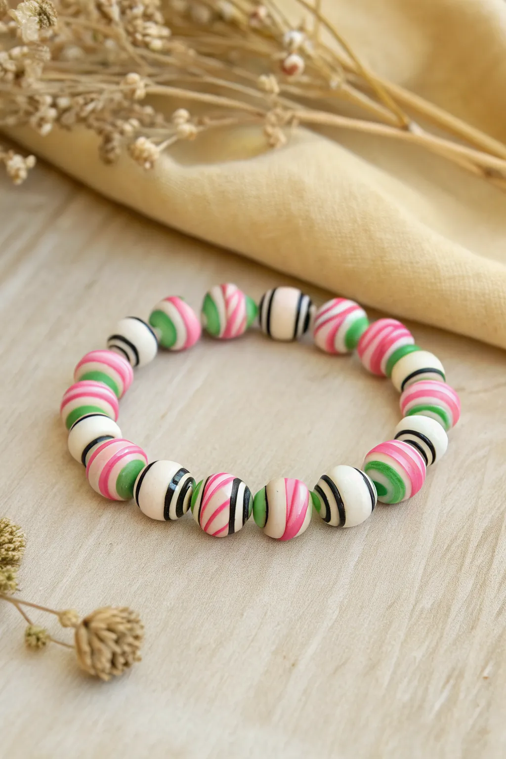 Twisted candy-stripe wicked spiral bracelet in pink, white, green, and black, neatly looped.
