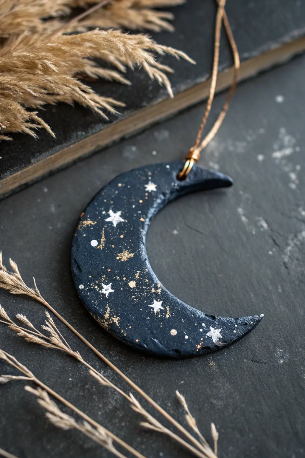 Celestial night-sky paint effect on a navy air-dry clay moon with star splatter and gold.