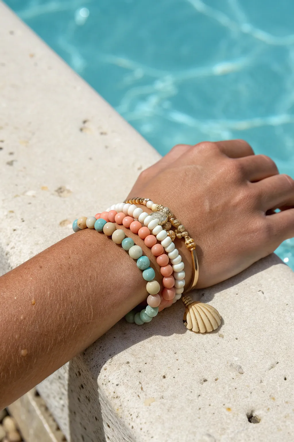 Sunlit clay bead bracelet stack by the pool, in soft beach tones for a waterproof-look vibe.