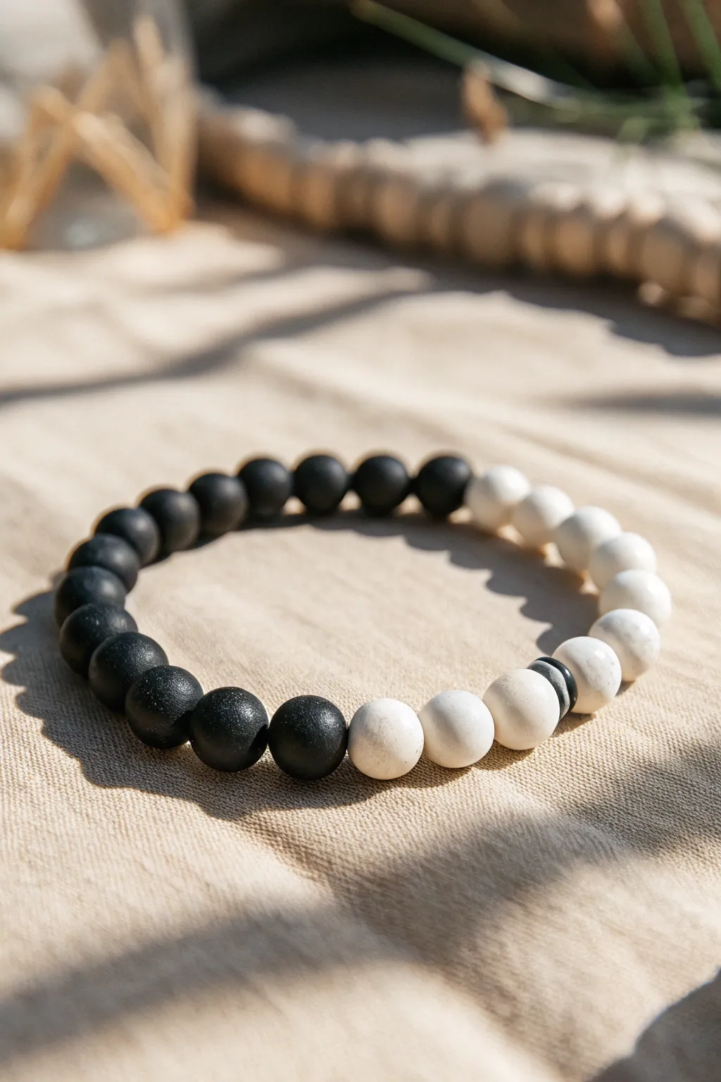Minimal clay bead bracelet with a dithered black to white fade, simple Scandinavian boho style.