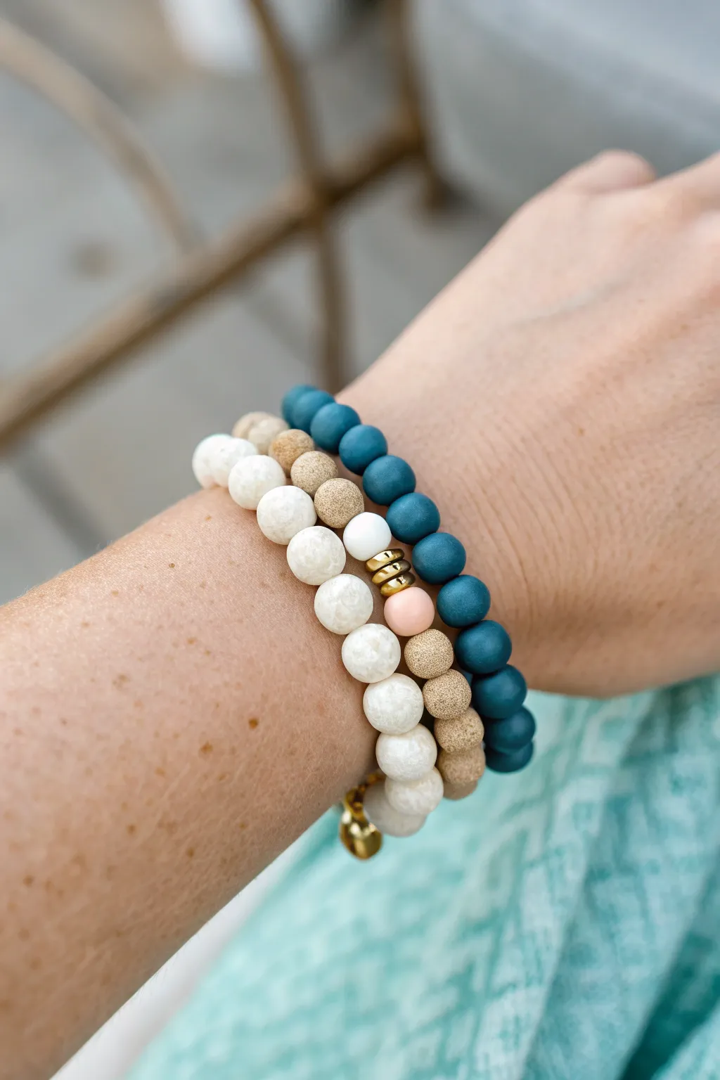 Mismatch stack with one shared color: pastel, ocean, and neutral clay bead bracelets that belong together.