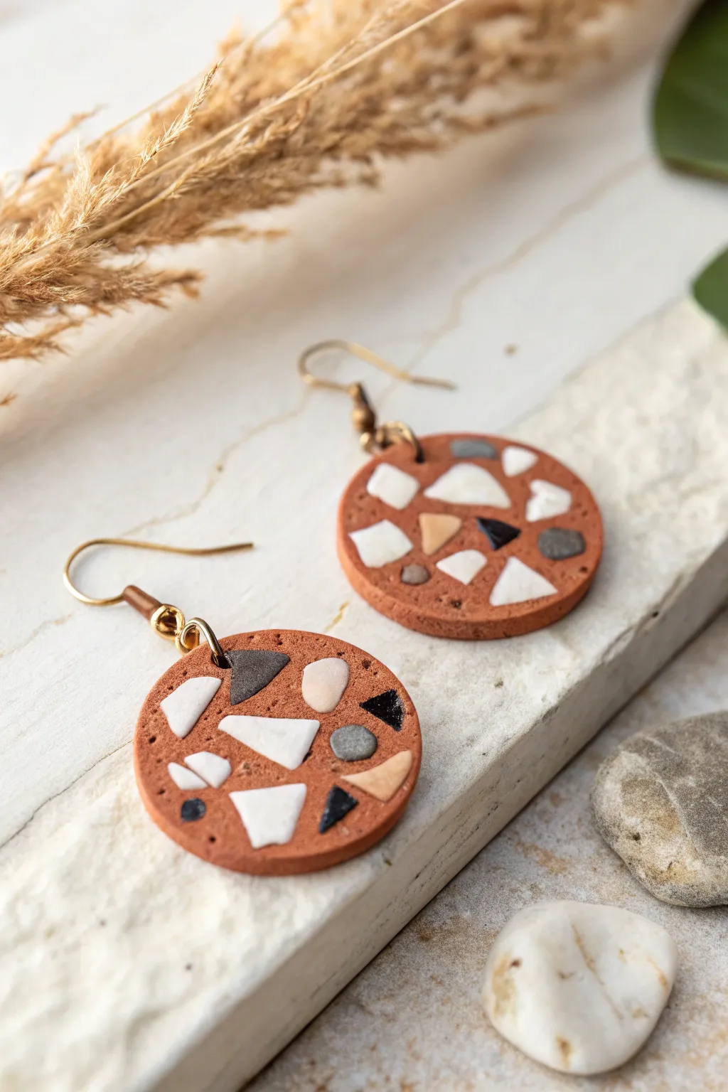 Minimalist clay inlay earring with mosaic accents, styled on pale stone for calm boho vibes.