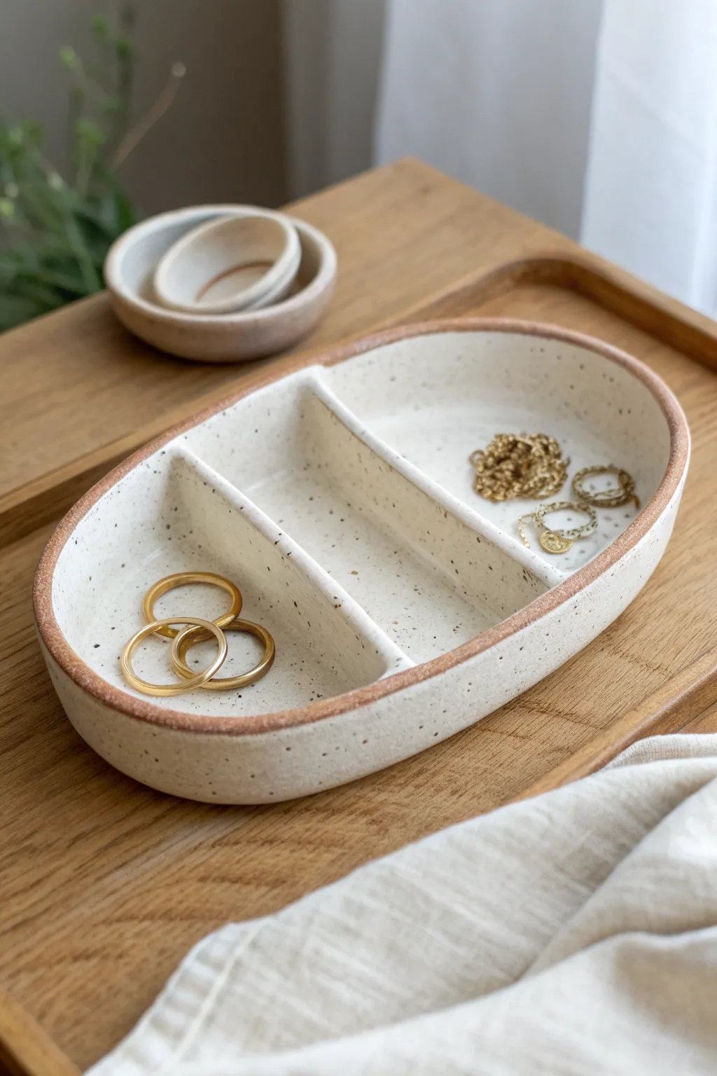 A simple sectioned clay trinket dish keeps rings and earrings beautifully organized.