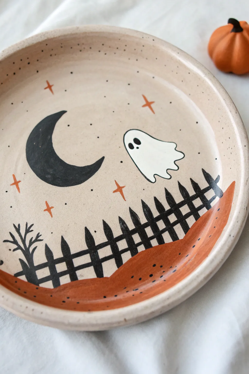 Minimalist Halloween plate with tiny ghost scene—simple shapes, bold contrast, cozy boho vibe.