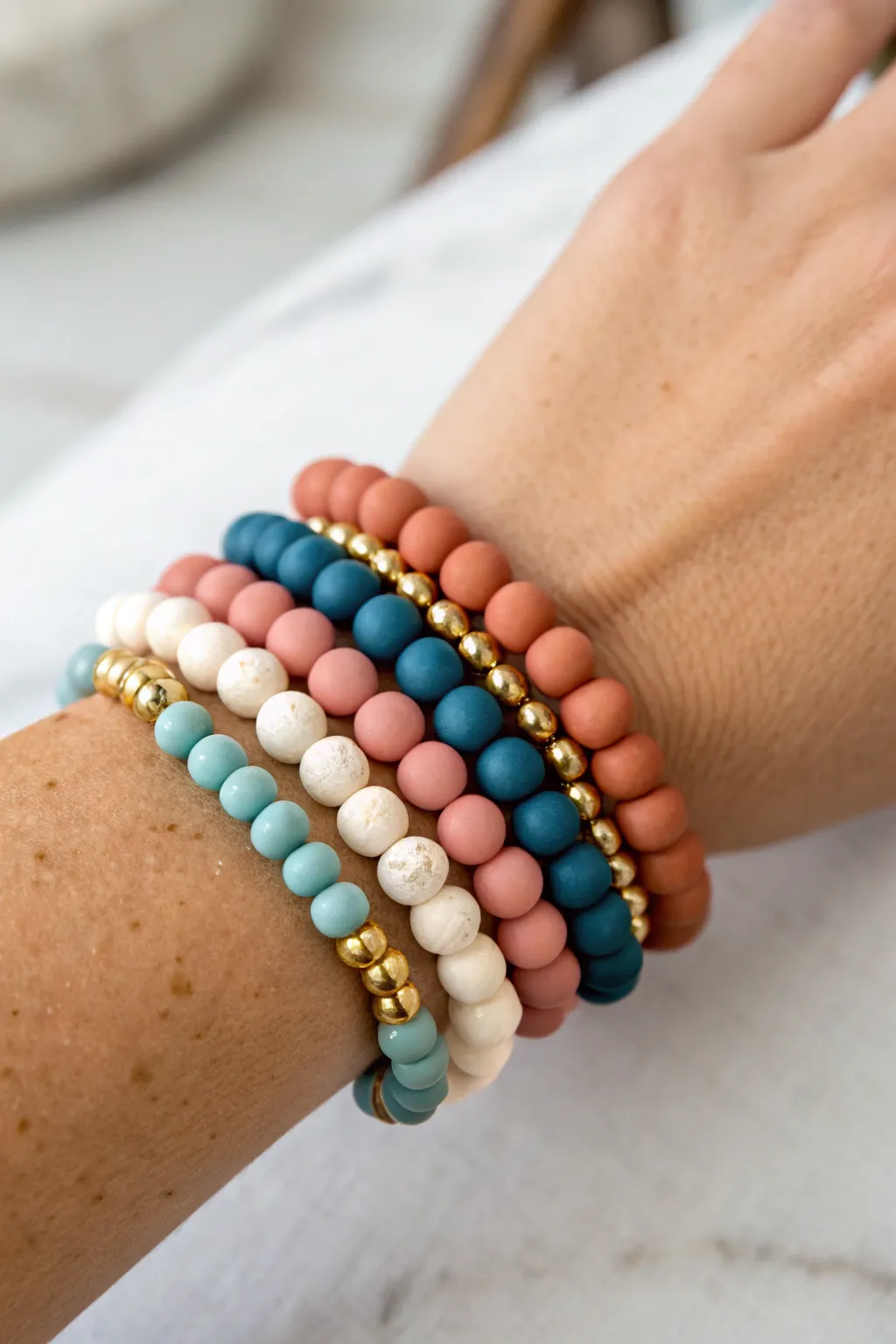 Mismatch but coordinated: 6 clay bead bracelets sharing white and gold for an intentional stack.