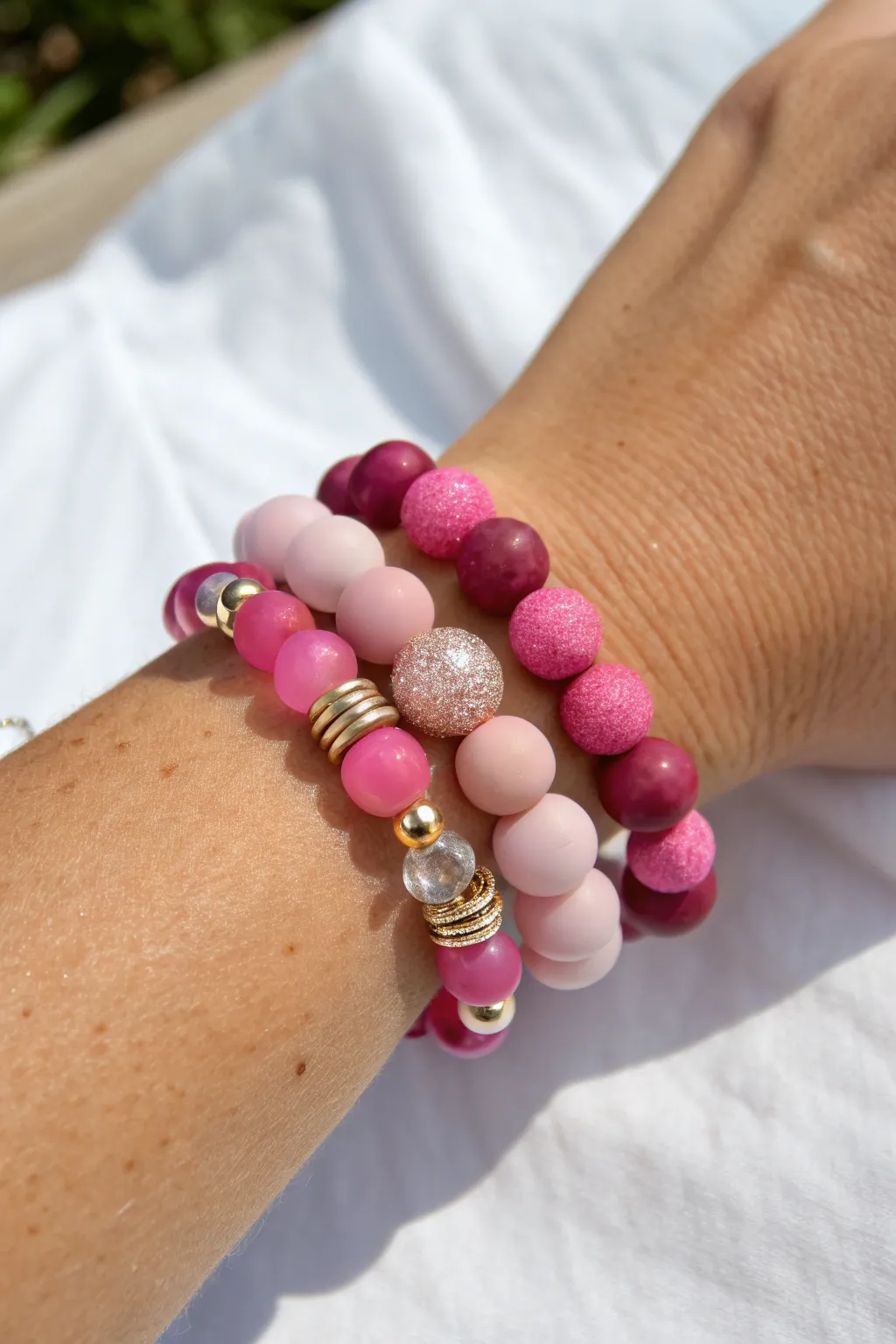 Shimmery pink clay bead party bracelet with clustered metallic spacers for a bold night-out glow.