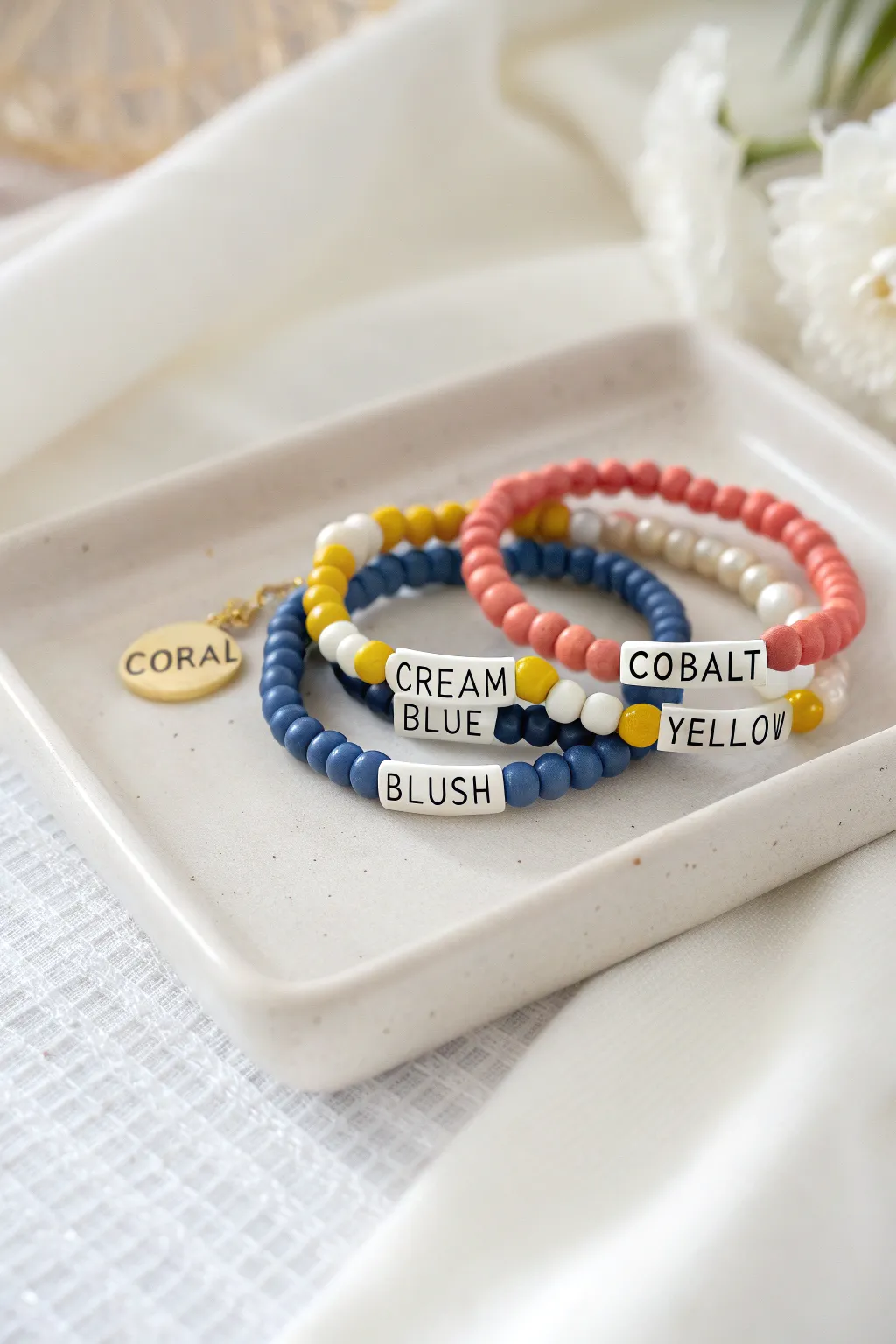 Three bold clay bead bracelets with cute letter-bead words, stacked in coordinated color palettes