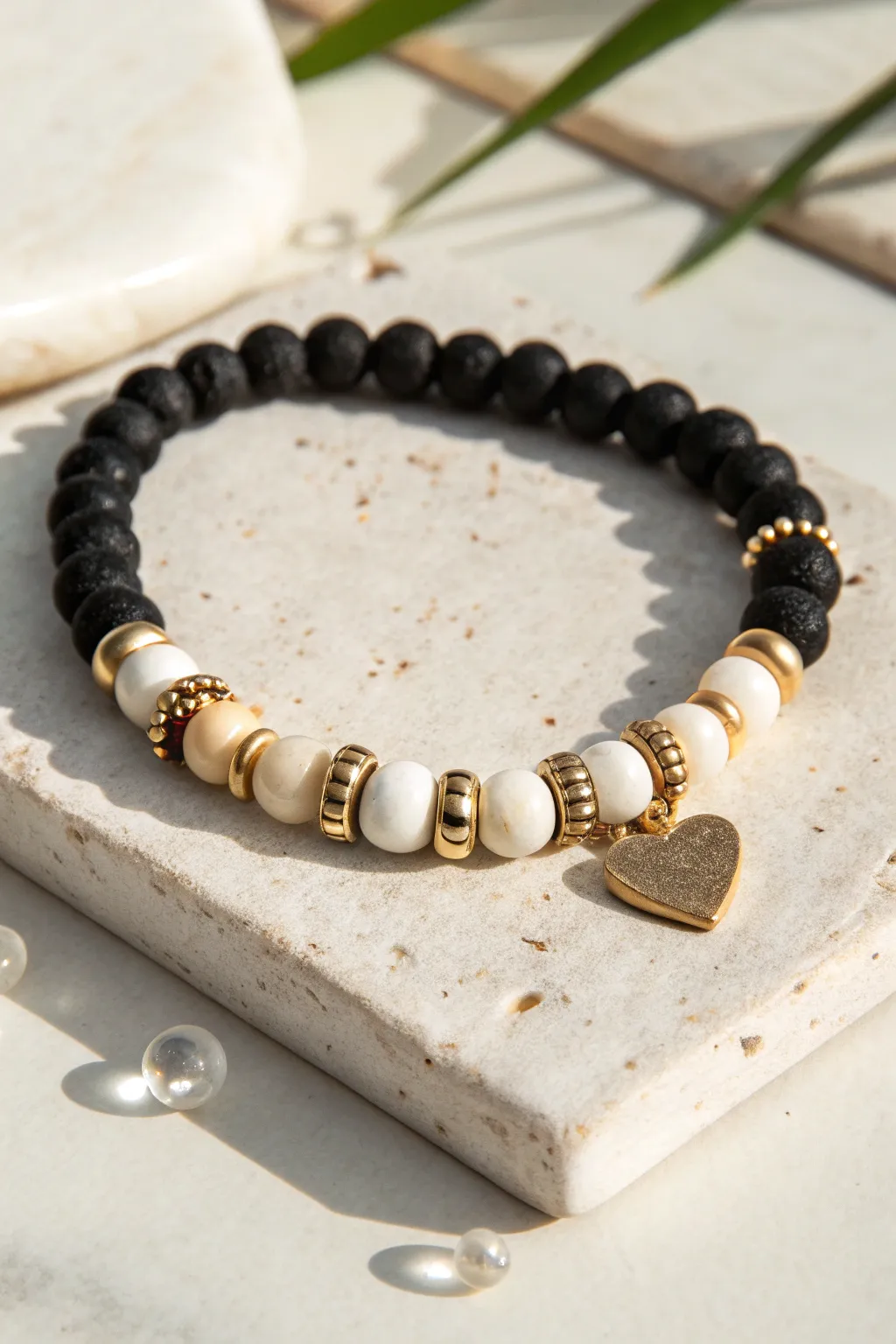 Midnight Kiss bracelet with a two-tone heart center, black and ivory heishi beads, and gold accents