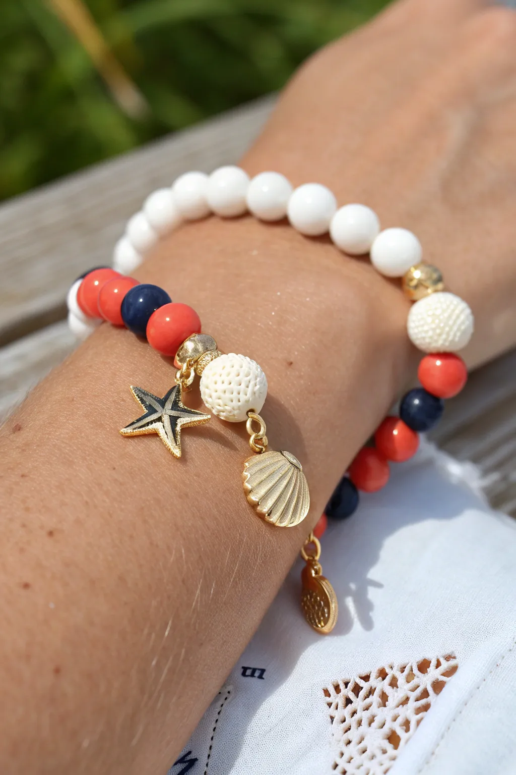 Preppy summer clay bead bracelet with a beachy charm cluster centerpiece, bright and minimal.