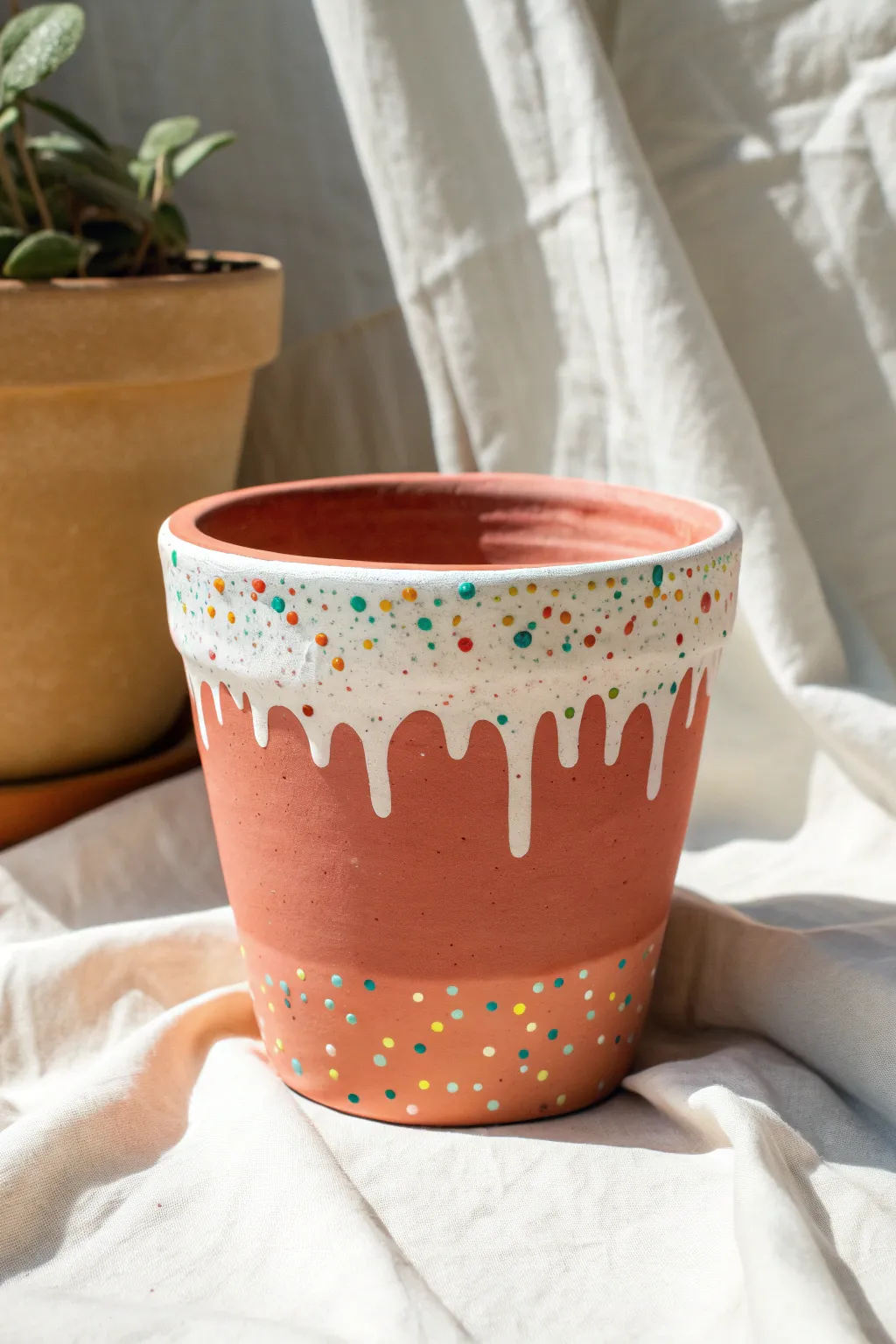 Sweet drippy glaze vibes: an easy painted clay pot with icing drips and playful sprinkles.