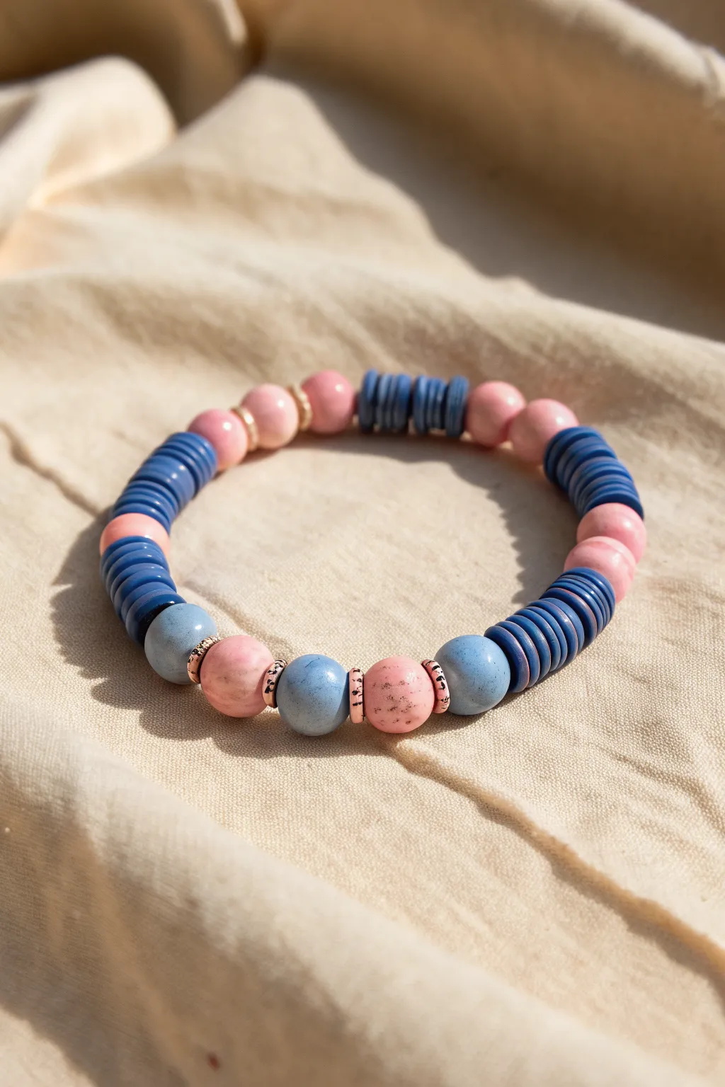 Playful heishi-and-round clay bead bracelet in blues and pinks, minimalist boho texture mix.