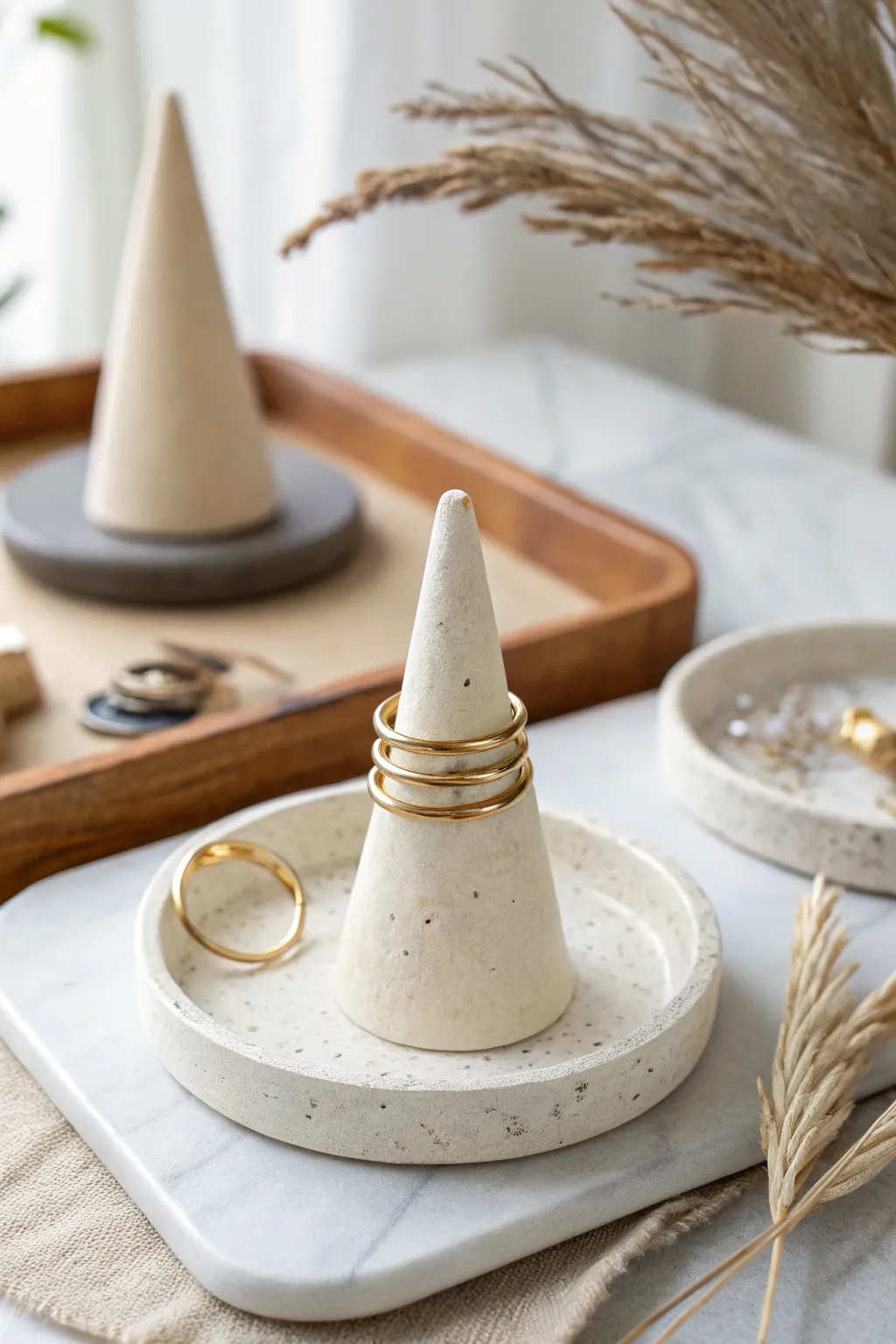 Minimal air clay cone ring holder with stacked rings, styled on a neutral bathroom tray