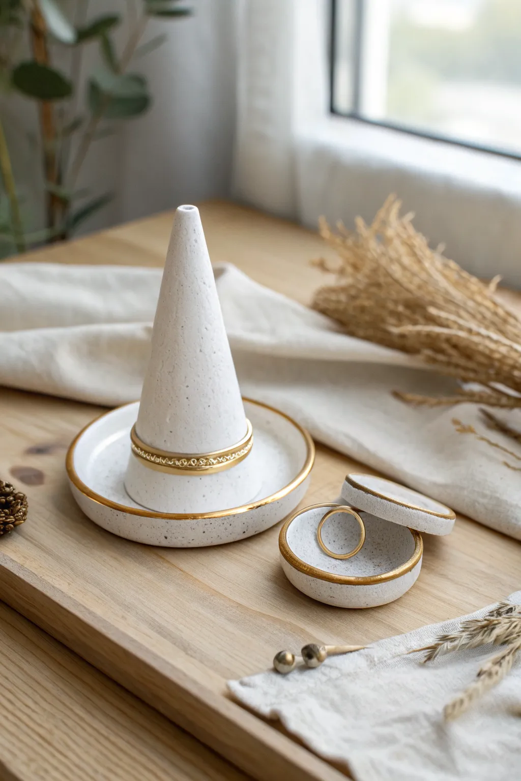 Minimal matte white ring cone with matching catch dish, finished with a delicate metallic rim.