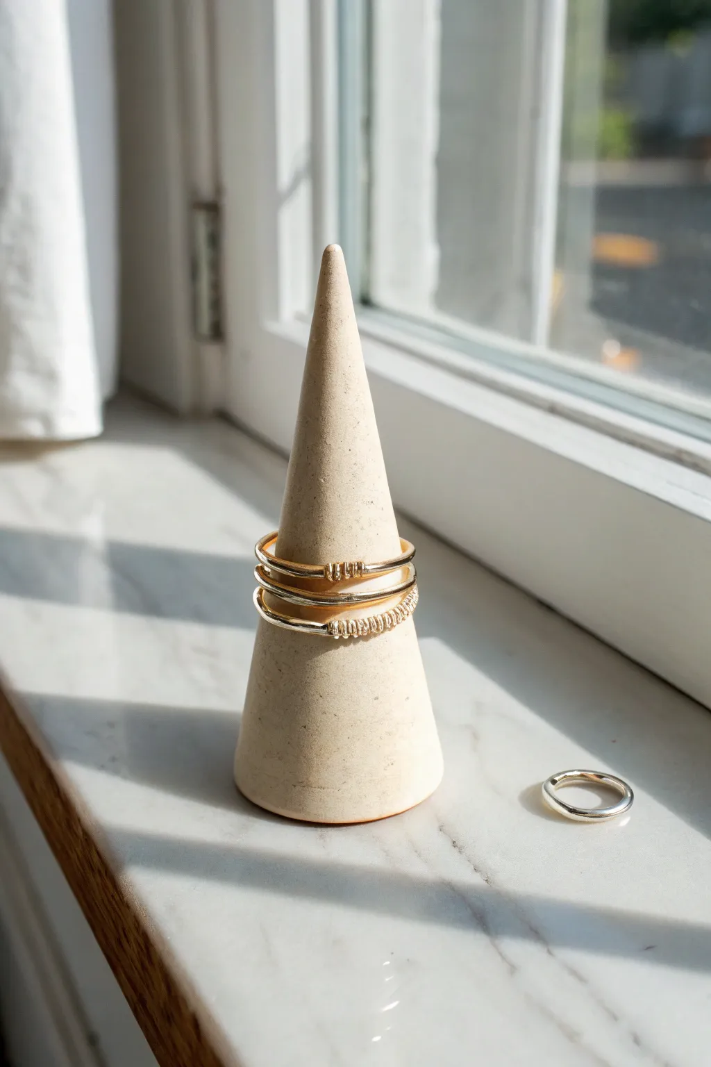 Minimal air dry clay ring cone in warm neutral tones, styled with stacked rings on a bright surface