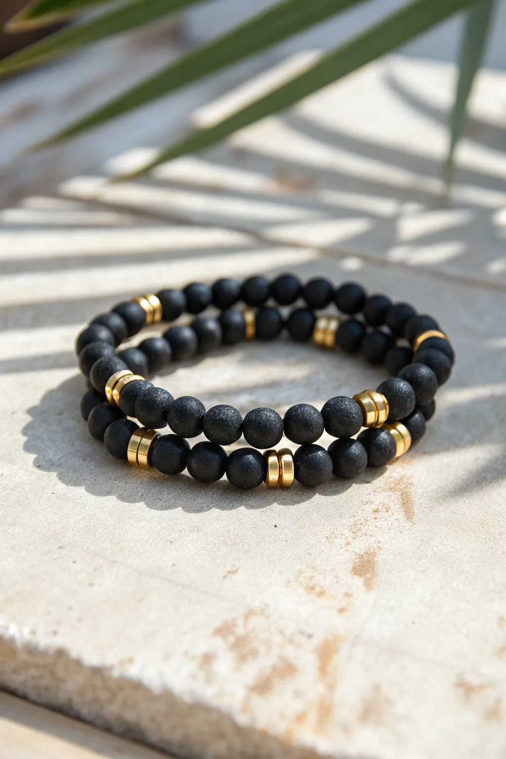 Matte black clay beads with golden spacers bring minimalist rhythm to an everyday stack.