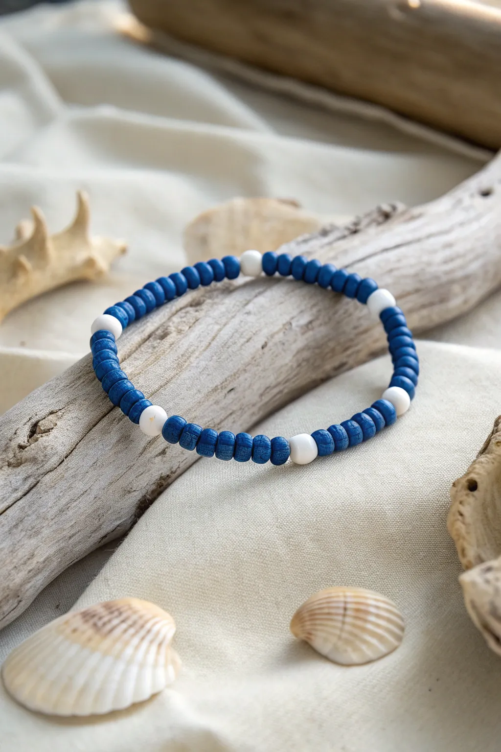 Ocean stripe bracelet: blue clay beads and white heishi on driftwood, crisp coastal minimalism