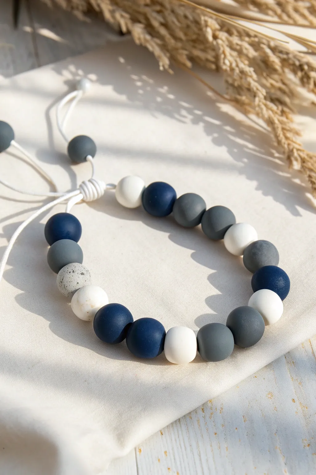 Chunky navy, gray, and white color-block clay bead bracelet with clean minimalist contrast.