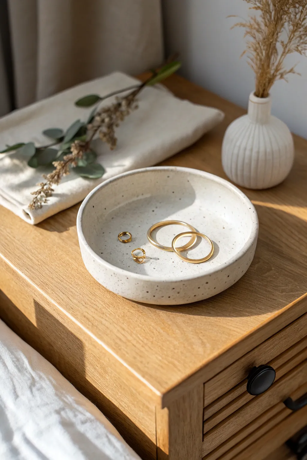 A simple circular clay dish with a soft rim, perfect for rings and earrings by the bed.