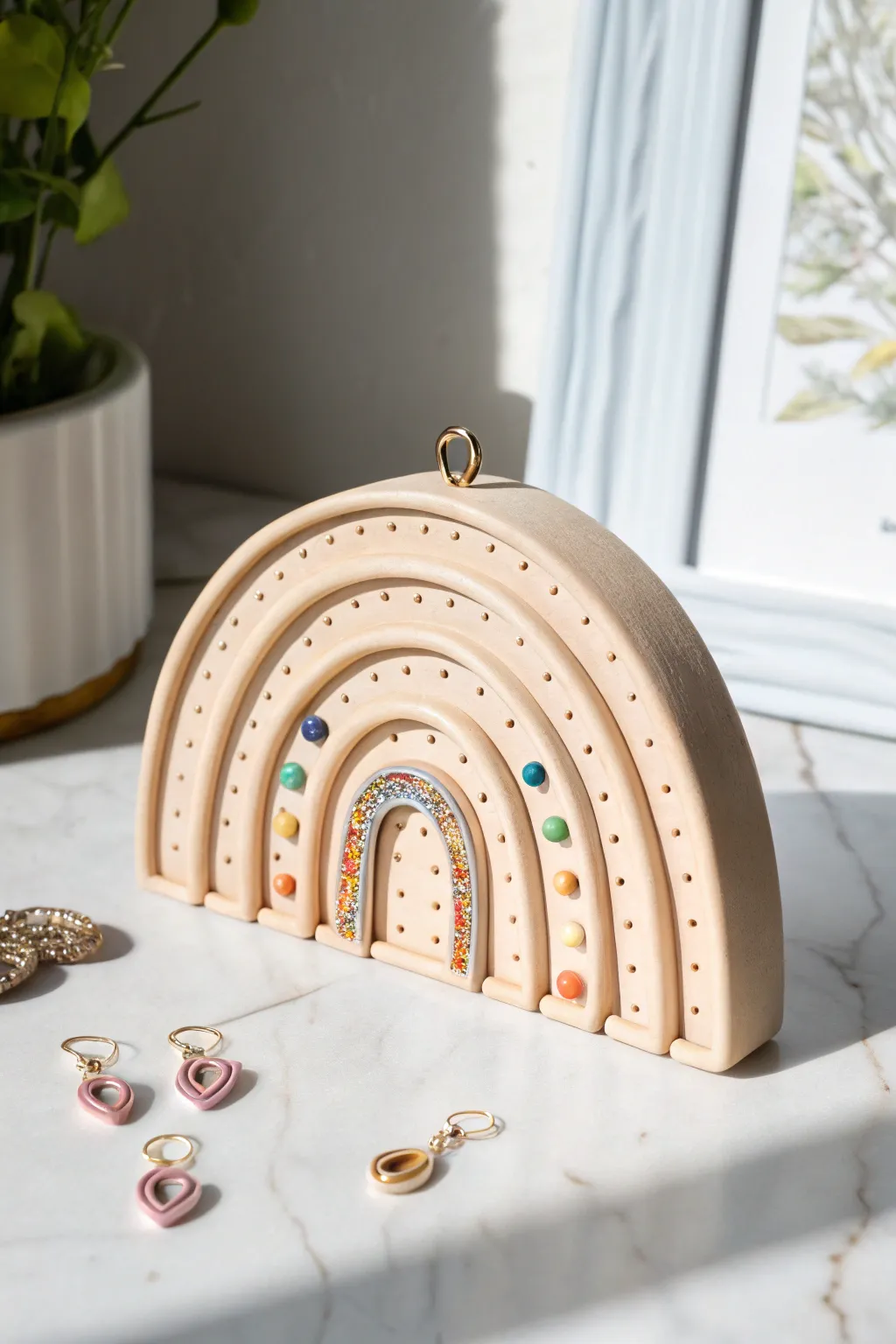 Minimal arched clay stud organizer, rainbow curve dotted with colorful earrings on marble