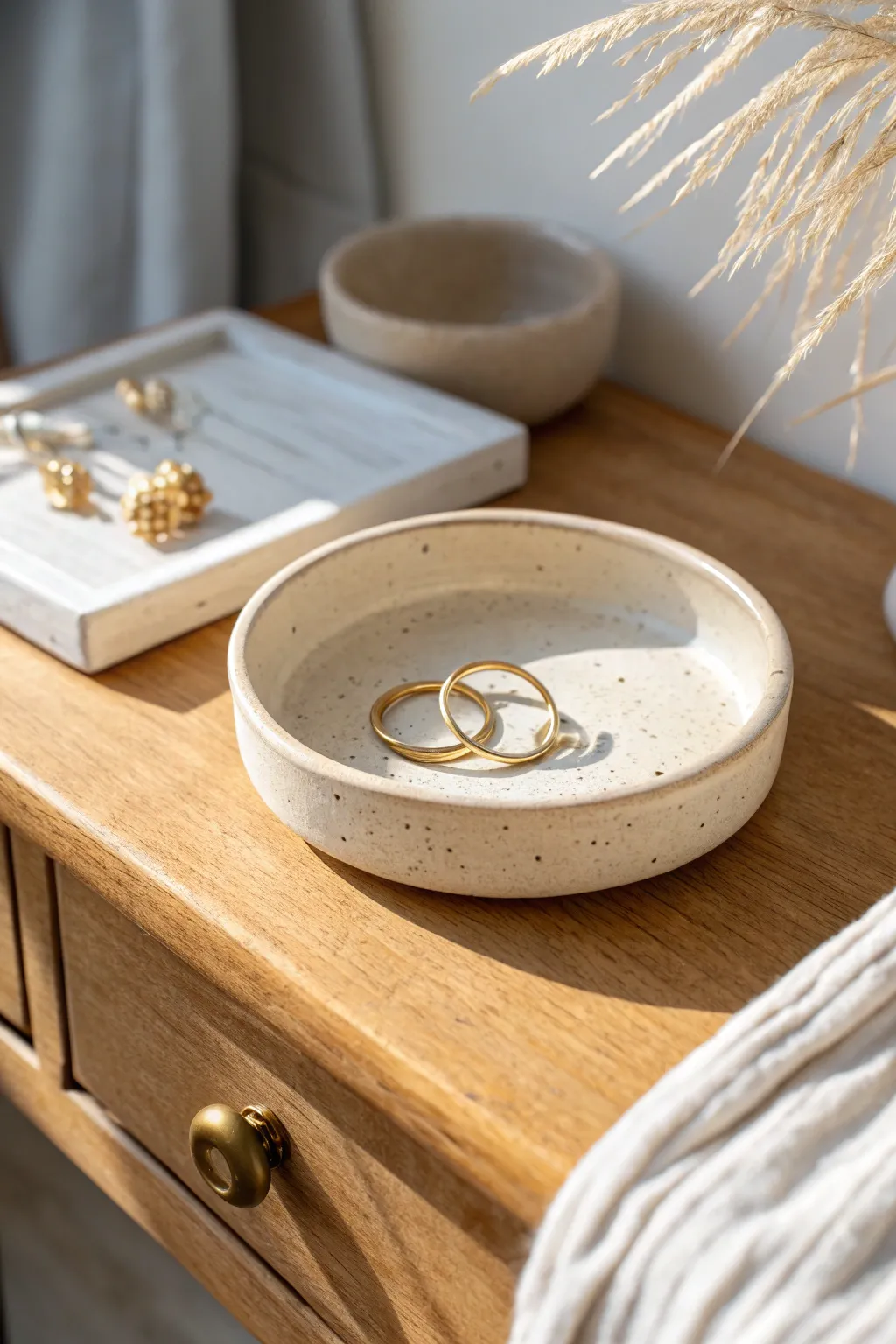 Minimal trinket dish with a centered ring post, styled softly for effortless bedside organization.