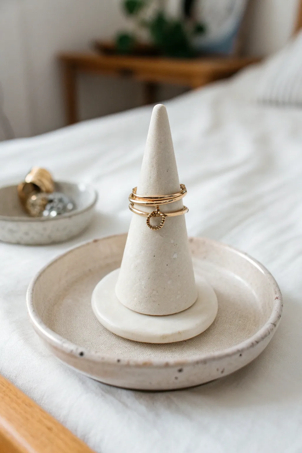 Minimal clay ring holder cone on a tiny dish, glossy and teen-room chic with soft neutral tones.