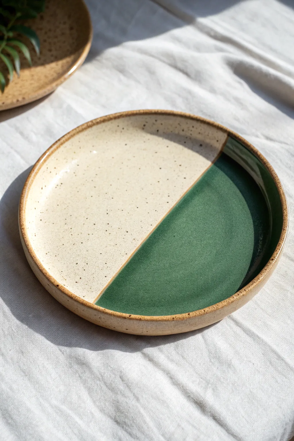Two-tone dip-glazed plate with a crisp graphic divide, Scandinavian minimalism with boho warmth