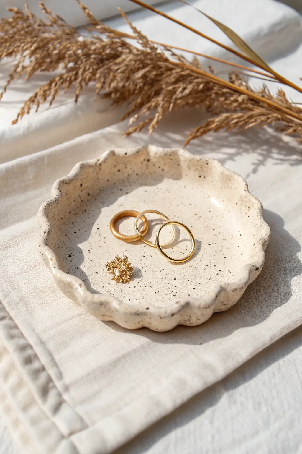 Wavy-edge clay trinket dish with delicate earrings, a minimalist boho catchall for tiny treasures.