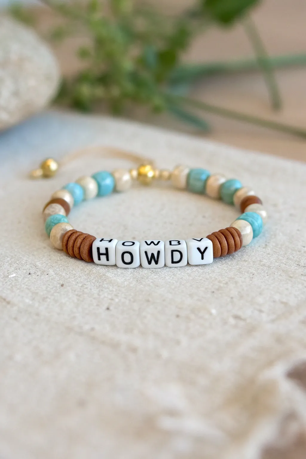 Scandi minimalist cowgirl bracelet with a HOWDY centerpiece, turquoise and cream clay beads