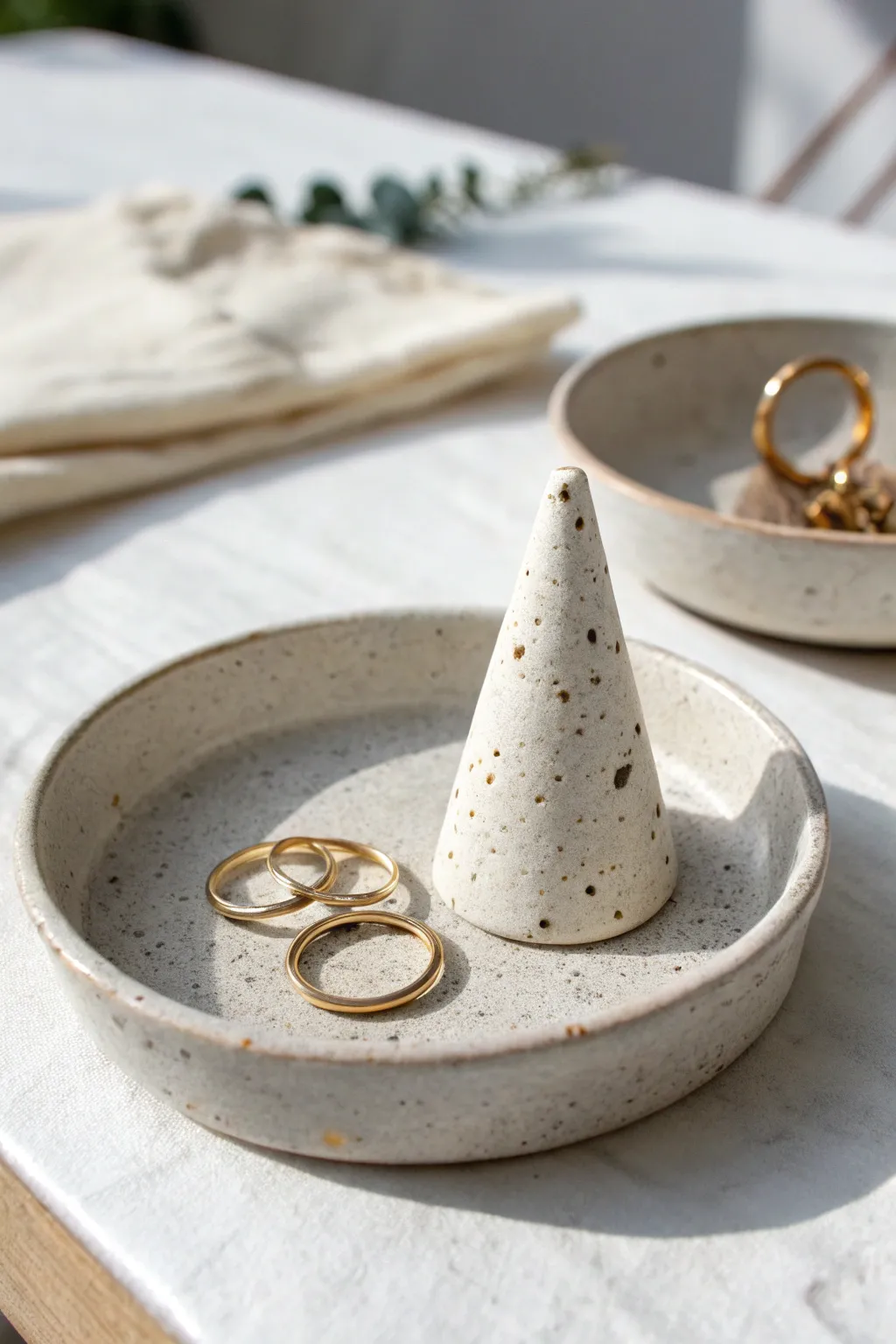 Minimal clay ring cone and dish with gold rings, styled in soft light for a cozy clean look