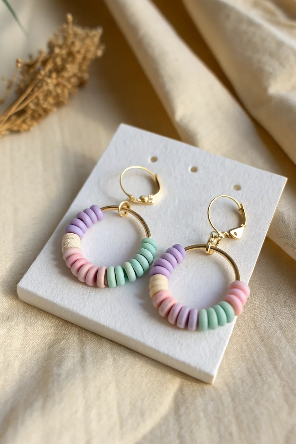 Pastel color-blocked mini hoops with chunky clay disc beads for an easy, modern handmade look.