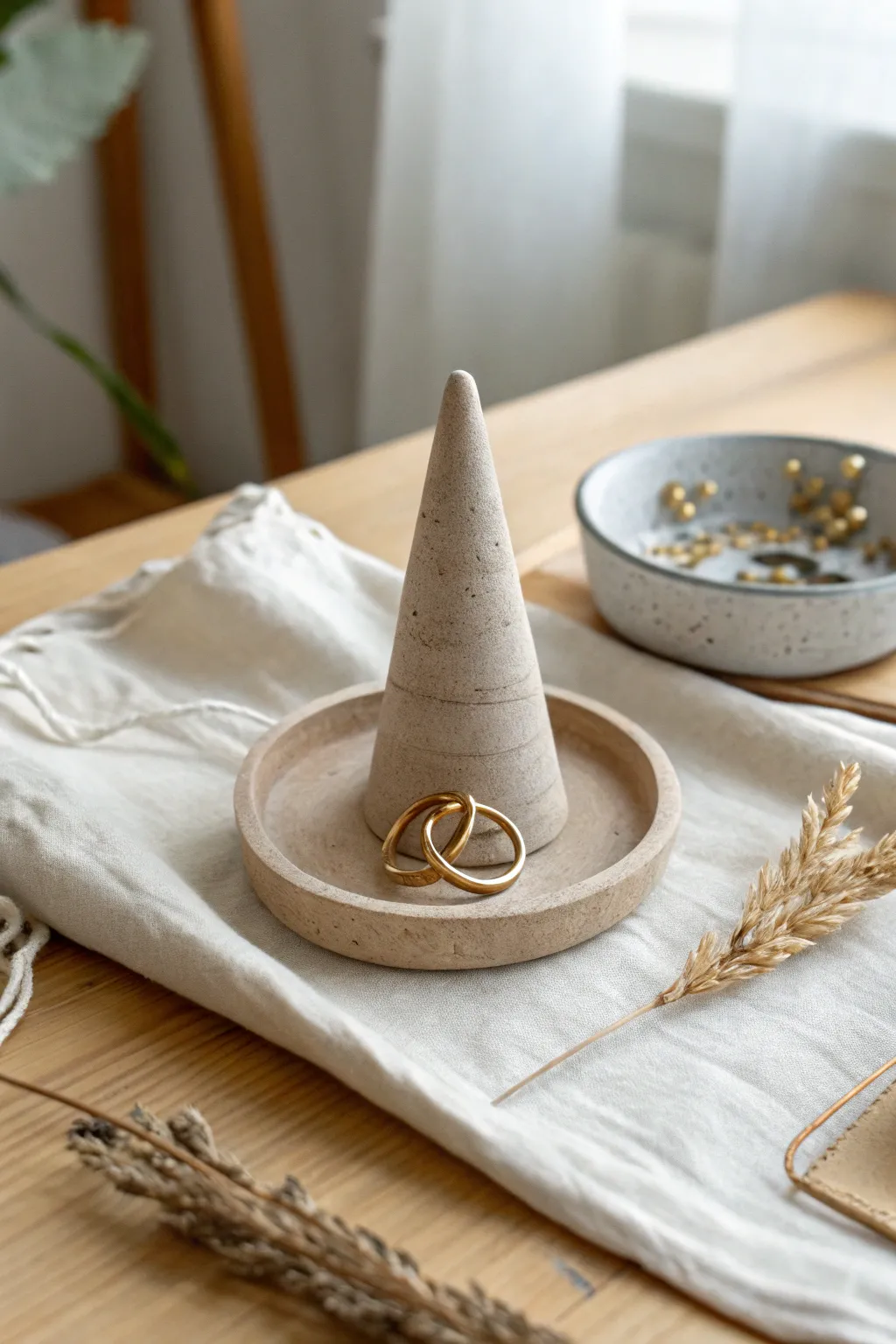 Minimal clay ring cone holder in matte greige, styled on oak with soft light and stacked rings