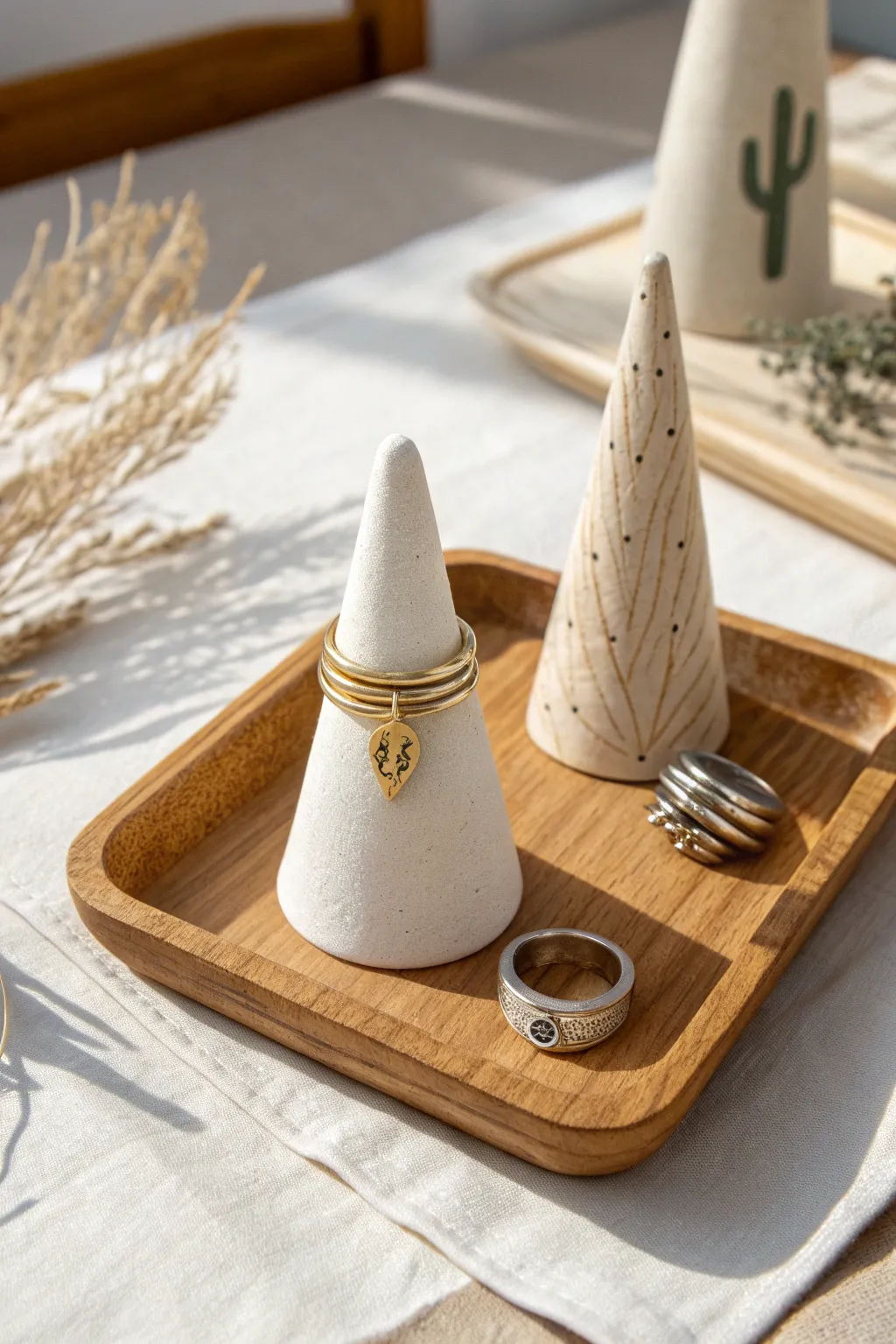 Minimal air-dry clay ring cones in soft neutrals, styled with rings for a calm boho look