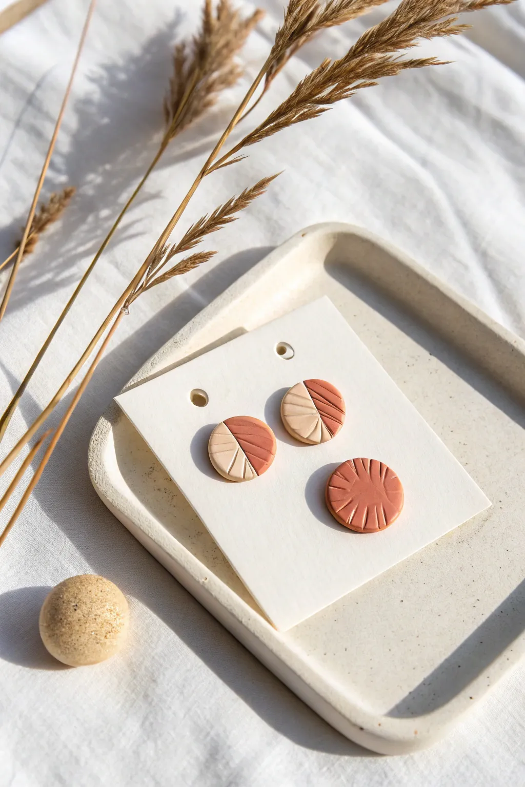 Minimal textured polymer clay circle studs in warm neutrals, styled simply for easy scale.
