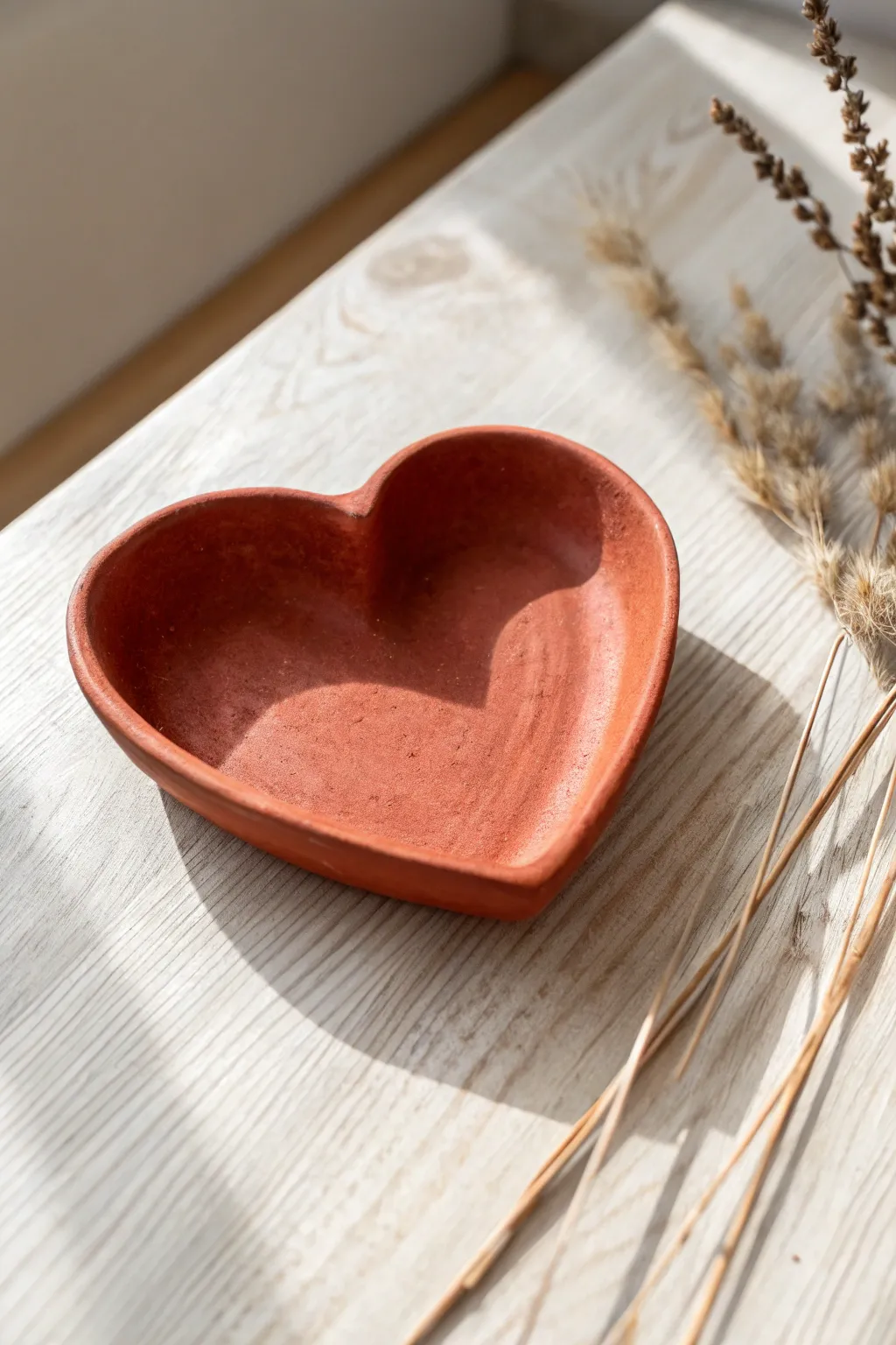 Simple heart-shaped red clay dish with cozy Scandinavian boho styling for rings and earrings.