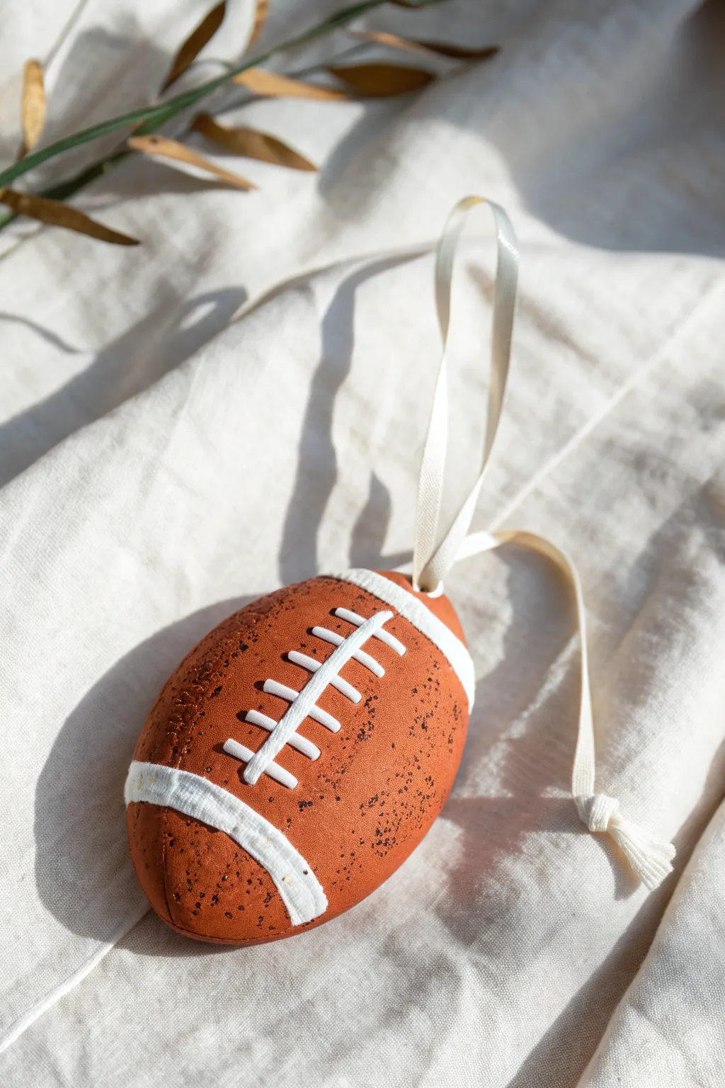 Classic lace-and-stripe clay football in soft neutrals, minimalist boho detail for your shelf.