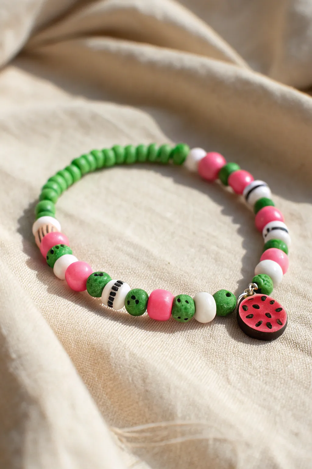 Watermelon pop bracelet in soft heishi tones, finished with tiny black seed-like spacers