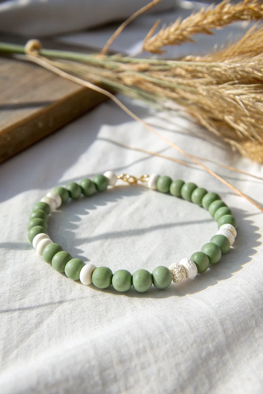 Sage green and white clay disc bracelet with a crisp minimalist rhythm and soft boho charm