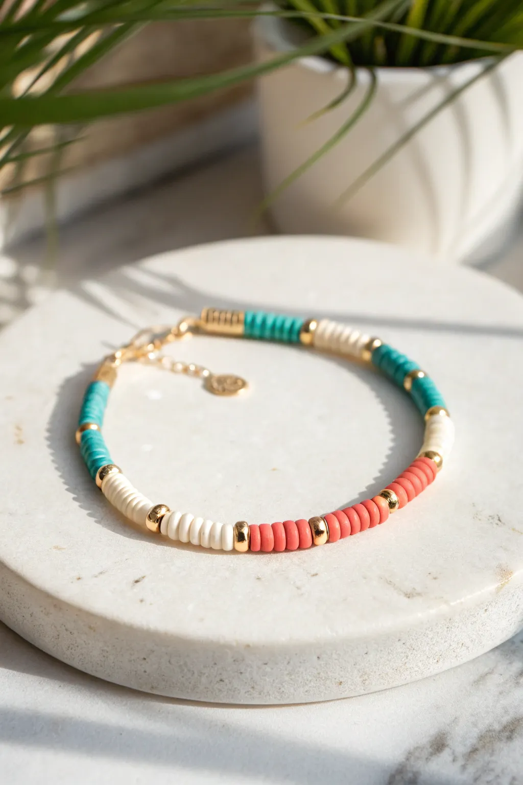 Simple color-block heishi bracelet in teal, coral, and cream with tiny spacer beads