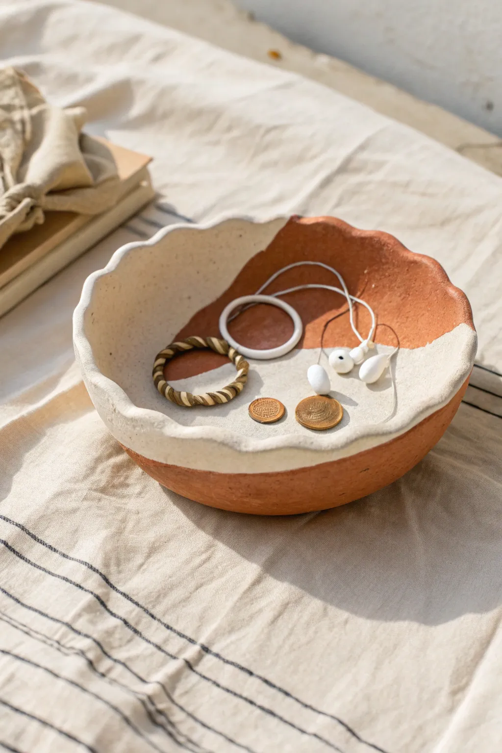 Wavy two tone clay trinket bowl that neatly holds earbuds, coins, and a hair tie.